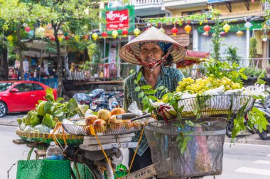 Vietnamlı kadın Hanoi, Vietnam 'da bisiklet üzerinde meyve satıyor.