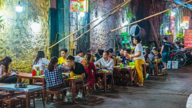 İnsanlar geceleri Hanoi 'nin Eski Mahallesi' nde sokak yemeği yiyorlar.