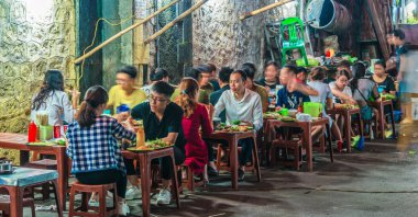 İnsanlar geceleri Hanoi 'nin Eski Mahallesi' nde sokak yemeği yiyorlar.
