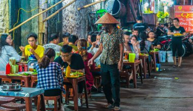 İnsanlar geceleri Hanoi 'nin Eski Mahallesi' nde sokak yemeği yiyorlar.