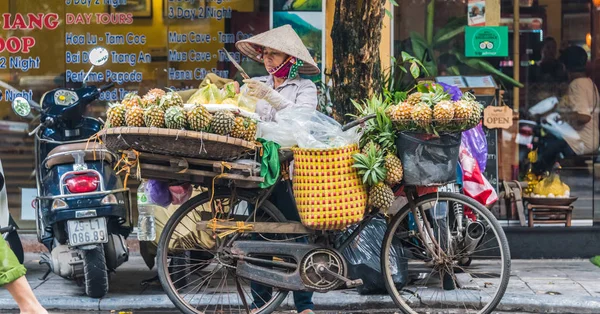 Vietnami nő gyümölcsöt árul kerékpáron Hanoiban, Vietnámban — Stock Fotó