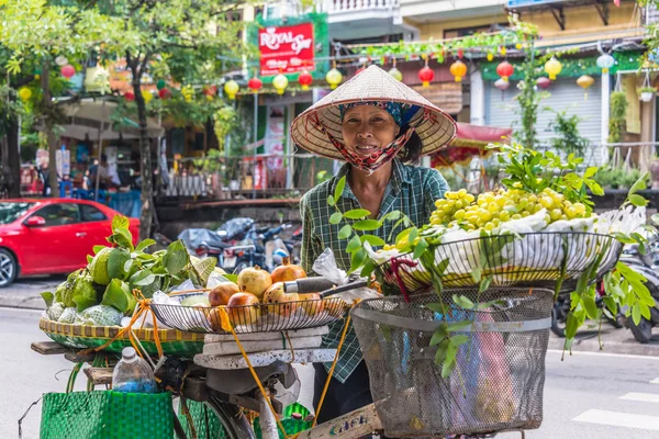 Mujer vietnamita vendiendo fruta en bicicleta en Hanoi, Vietnam — Foto de Stock