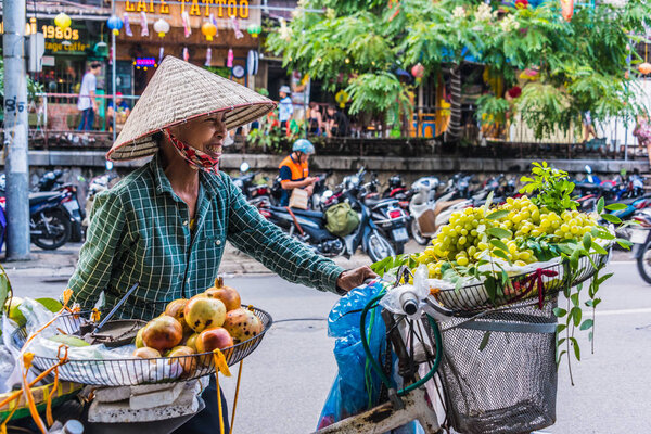 Vietnamese woman selling fruit on a bike in Hanoi, Vietnam
