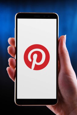 POZNAN, POL - 21 Mayıs 2020: Bir sosyal medya ağı ve mobil uygulama şirketi olan Pinterest, Inc. 'in logosunu gösteren akıllı telefonu tutan eller
