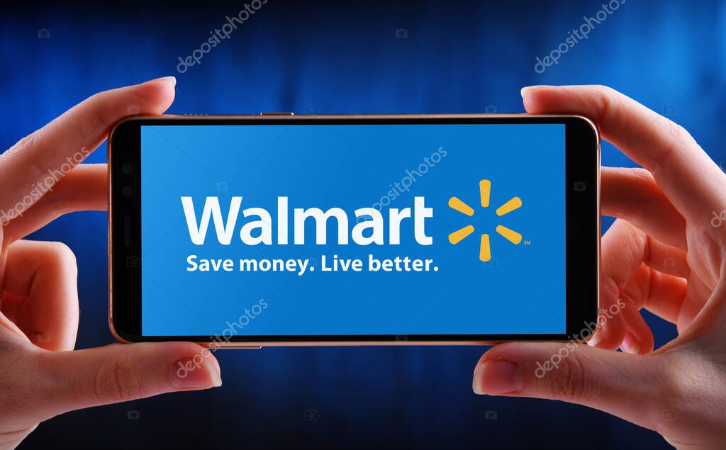 POZNAN, POL - MAY 21, 2020: Hands holding smartphone displaying logo of Walmart Inc., an American multinational retail corporation headquartered in Bentonville, Arkansas