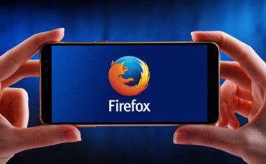 POZNAN, POL - 21 Mayıs 2020: Firefox 'un ücretsiz ve açık kaynaklı web tarayıcısı logosunu gösteren akıllı telefonu tutan eller.