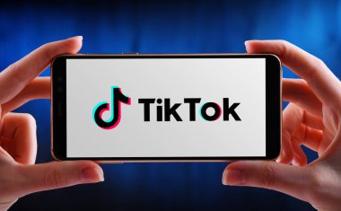 POZNAN, POL - 21 Mayıs 2020: ByteDance 'e ait bir Çin video paylaşım sosyal ağ servisi olan TikTok' un akıllı telefon logosunu gösteren eller
