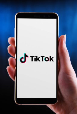 POZNAN, POL - 21 Mayıs 2020: ByteDance 'e ait bir Çin video paylaşım sosyal ağ servisi olan TikTok' un akıllı telefon logosunu gösteren eller