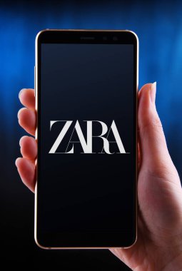 POZNAN, POL - 21 Mayıs 2020: Galiçya 'daki Arteixo' da bulunan İspanyol giyim perakendecisi Zara 'nın akıllı telefon logosunu gösteren eller