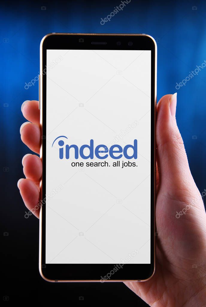 POZNAN, POL - MAY 21, 2020: Hands holding smartphone displaying logo of Indeed is an American worldwide employment-related search engine for job listings