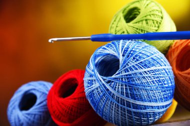 Değişik renkli ipliklerden oluşan kompozisyon ve örgü örmek için kanca.