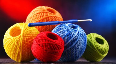 Değişik renkli ipliklerden oluşan kompozisyon ve örgü örmek için kanca.