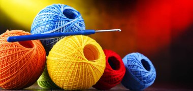 Değişik renkli ipliklerden oluşan kompozisyon ve örgü örmek için kanca.