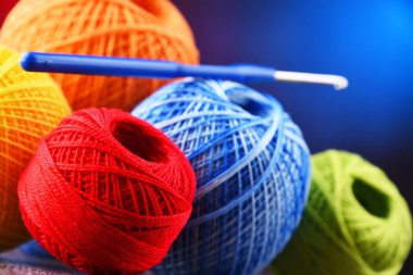 Değişik renkli ipliklerden oluşan kompozisyon ve örgü örmek için kanca.