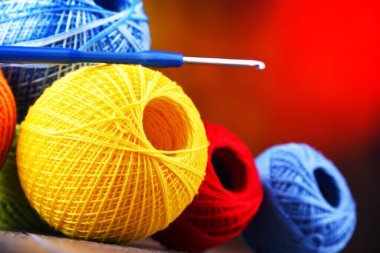 Değişik renkli ipliklerden oluşan kompozisyon ve örgü örmek için kanca.