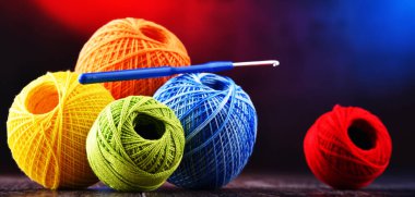 Değişik renkli ipliklerden oluşan kompozisyon ve örgü örmek için kanca.