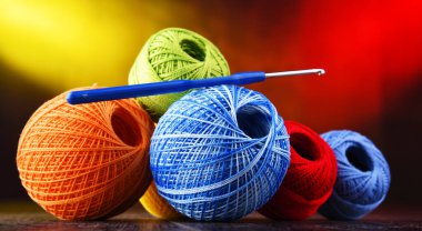 Değişik renkli ipliklerden oluşan kompozisyon ve örgü örmek için kanca.