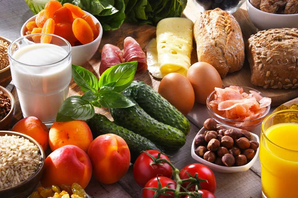 Ahşap mutfak masasında çeşitli organik gıda ürünleri..
