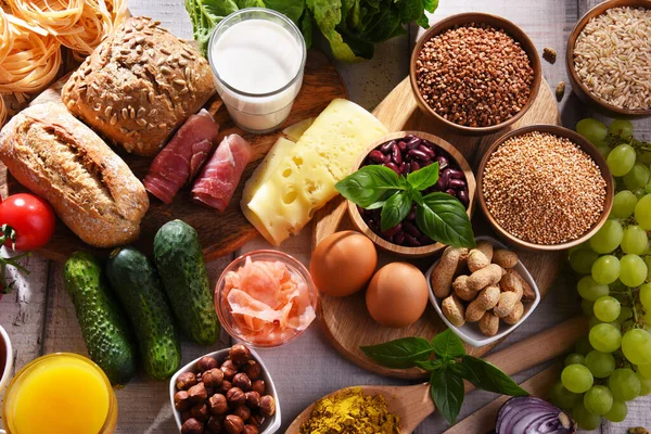 Composition with assorted organic food products on wooden kitchen table.