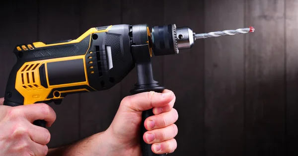 Male hands holding power drill.