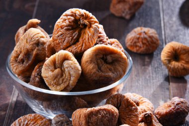 Ahşap masada bir kase kurutulmuş incir ile kompozisyon.