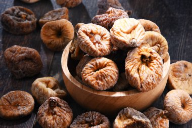 Ahşap masada bir kase kurutulmuş incir ile kompozisyon.