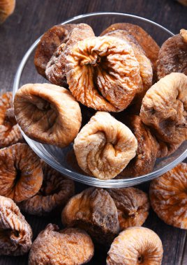 Ahşap masada bir kase kurutulmuş incir ile kompozisyon.