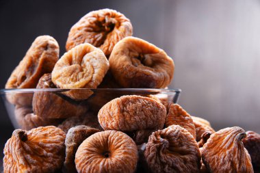 Ahşap masada bir kase kurutulmuş incir ile kompozisyon.