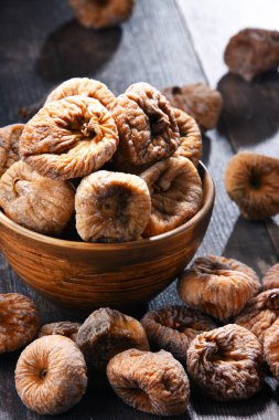 Ahşap masada bir kase kurutulmuş incir ile kompozisyon.