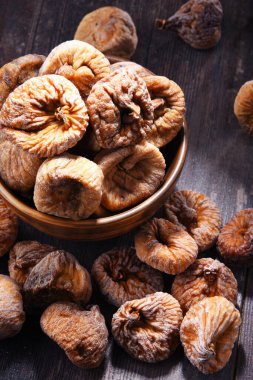 Ahşap masada bir kase kurutulmuş incir ile kompozisyon.