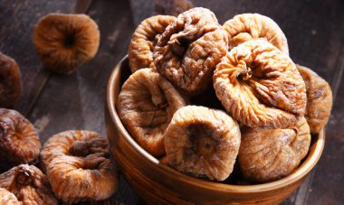 Ahşap masada bir kase kurutulmuş incir ile kompozisyon.