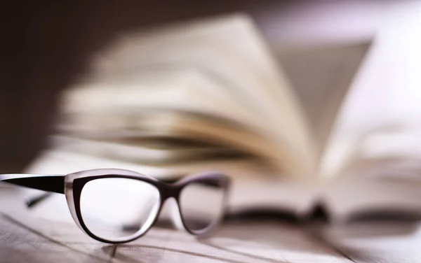 Komposition Mit Brille Und Aufgeschlagenem Buch Auf Dem Tisch — Stockfoto