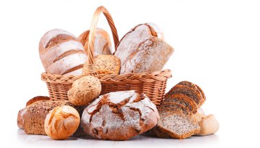 Hasır sepetin içindeki çeşitli fırın ürünleriyle beyazı izole edilmiş kompozisyon