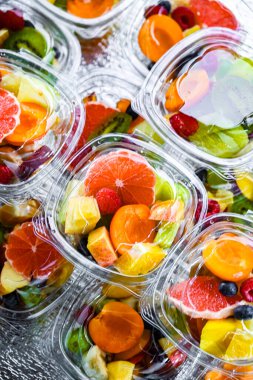 Plastic boxes with pre-packaged fruit salads, put up for sale in a commercial refrigerator