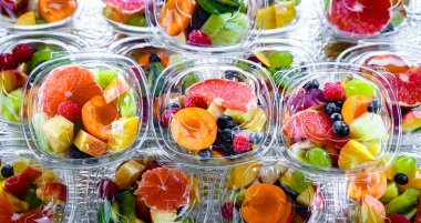 Plastic boxes with pre-packaged fruit salads, put up for sale in a commercial refrigerator