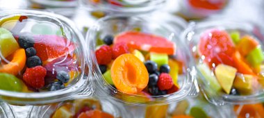 Plastic boxes with pre-packaged fruit salads, put up for sale in a commercial refrigerator