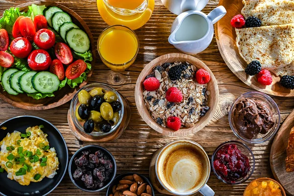 Kahvaltının yanında kahve, portakal suyu, kruvasan, mısır gevreği, çırpılmış yumurta ve krep var..