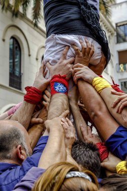 Badalona, Spain - May 13, 2018: Some unidentified people called Castellers do a Castell or Human Tower, typical tradition in Catalonia, Major festivals of the city. clipart