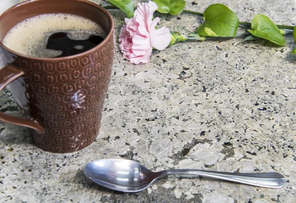 Granite countertop with coffee and flower on it