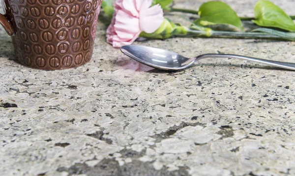 Cup of coffee and flower on kitchen counter top made of granite stone