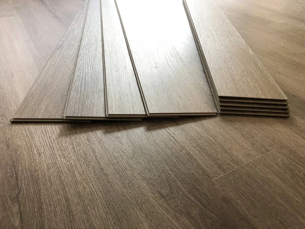 Lüks vinil tahta laminat parke kavramı. İşçi yeni kat yükleme için hazırlama