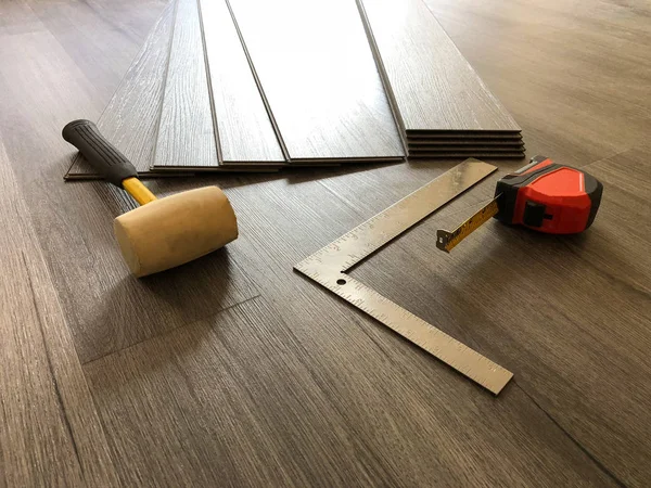 Lüks vinil tahta laminat parke kavramı. Çalışan araçları ile yeni kat yükleme için hazırlama