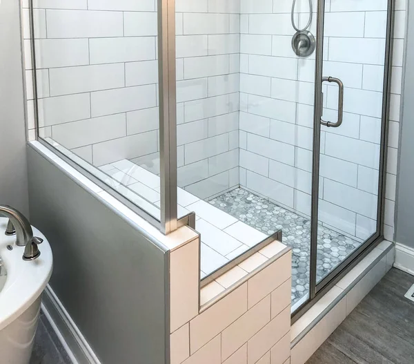 Banyo duş beyaz dikdörtgen duvar karoları, özel duş koltuk, içinde duş temel ve kahverengimsi zemini Mozaik yer karoları ile temel. Cam duş kapı ve kapı aynası ile krom banyo armatürleri 