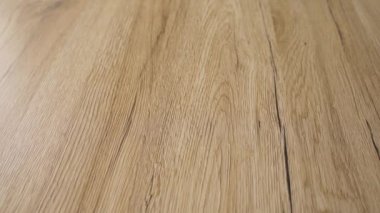 Modern parke döşeme Üst kaydırma 4k yavaş çekim video. Bitmiş zemin kahverengi taneleri ve açık sert ahşap renkleri ile doğal kırmızı akçaağaç ahşap yapılır. Yenileme ve ev geliştirme konsepti