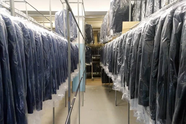 휴일용 양복은 창고에 보관되어 창고에서 물건을 준비하고 구입하는 공장에서 일하는 — 스톡 사진