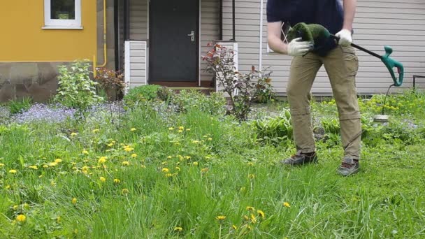 Чоловічий Садівник Очищає Електричний Тример Працюючи Подвір Від Сирої Трави — стокове відео