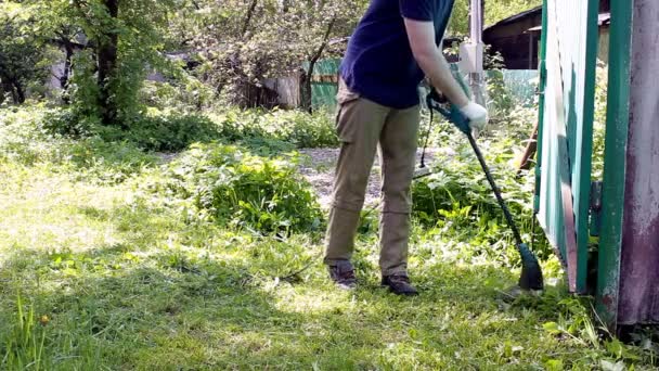 Wysoki Mężczyzna Niebieskiej Koszulce Masce Medycznej Kosi Trawnik Kosiarką Elektryczną — Wideo stockowe