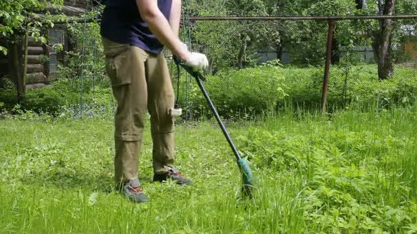 Wysoki Mężczyzna Niebieskiej Koszulce Masce Medycznej Kosi Trawnik Kosiarką Elektryczną — Wideo stockowe