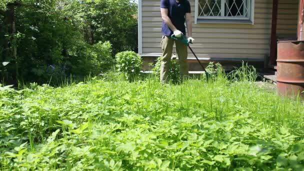 Ein Gärtner Reinigt Während Seiner Arbeit Hof Einen Trimmer Von — Stockvideo