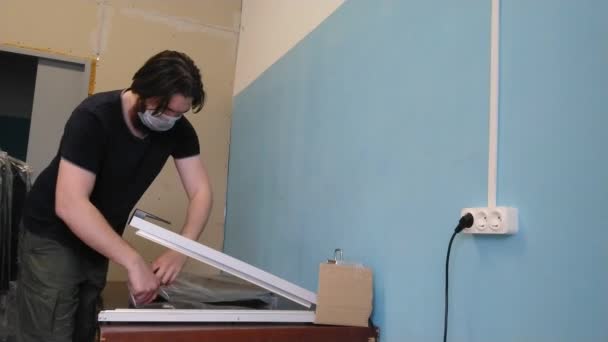 사람들은 마스크를 공장에서 일한다 근로자는 기술을 사용하여 옷으로 플라스틱 가방을 — 비디오